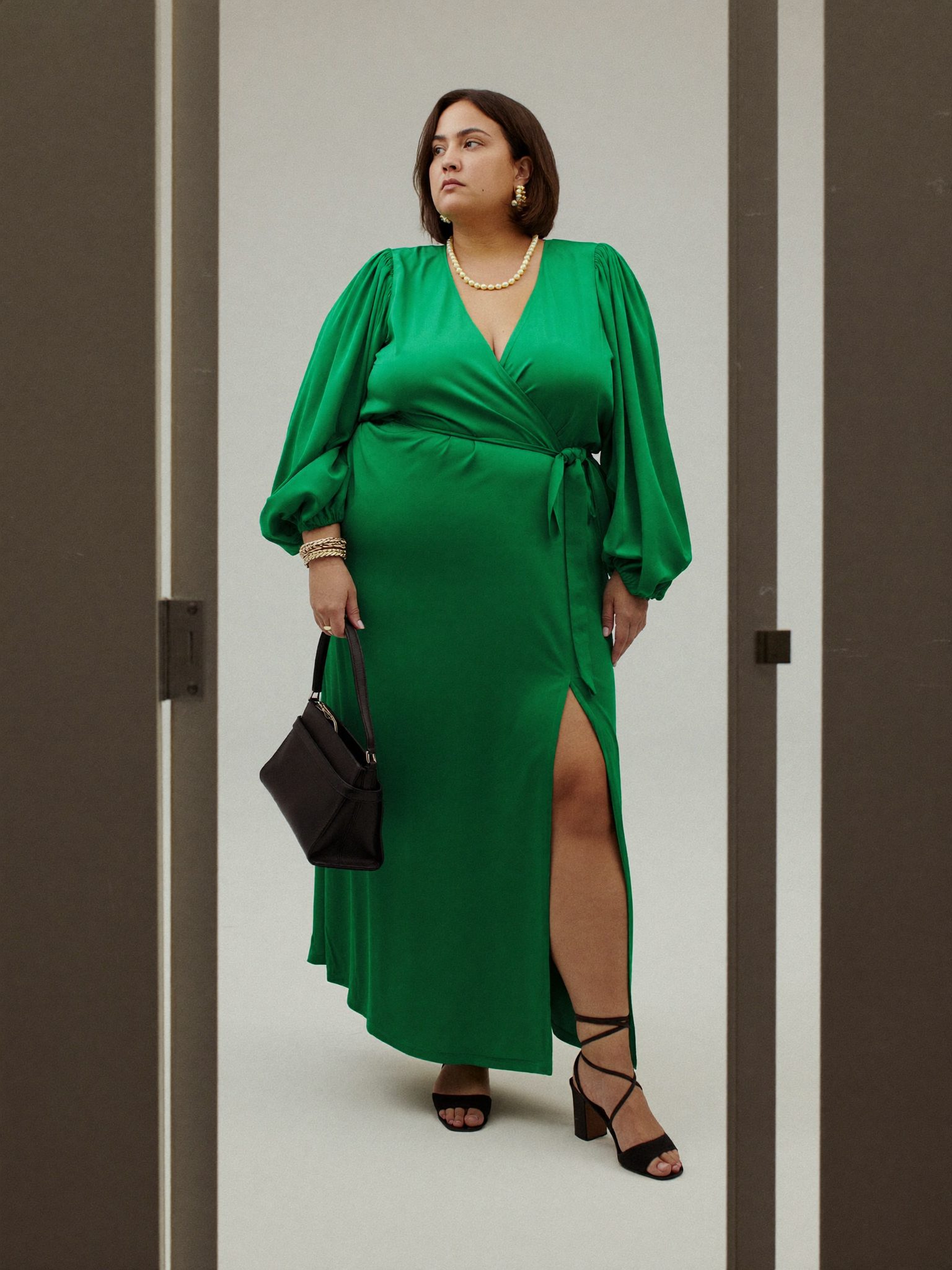 Девушка plus size в платье с запахом цвета изумруд